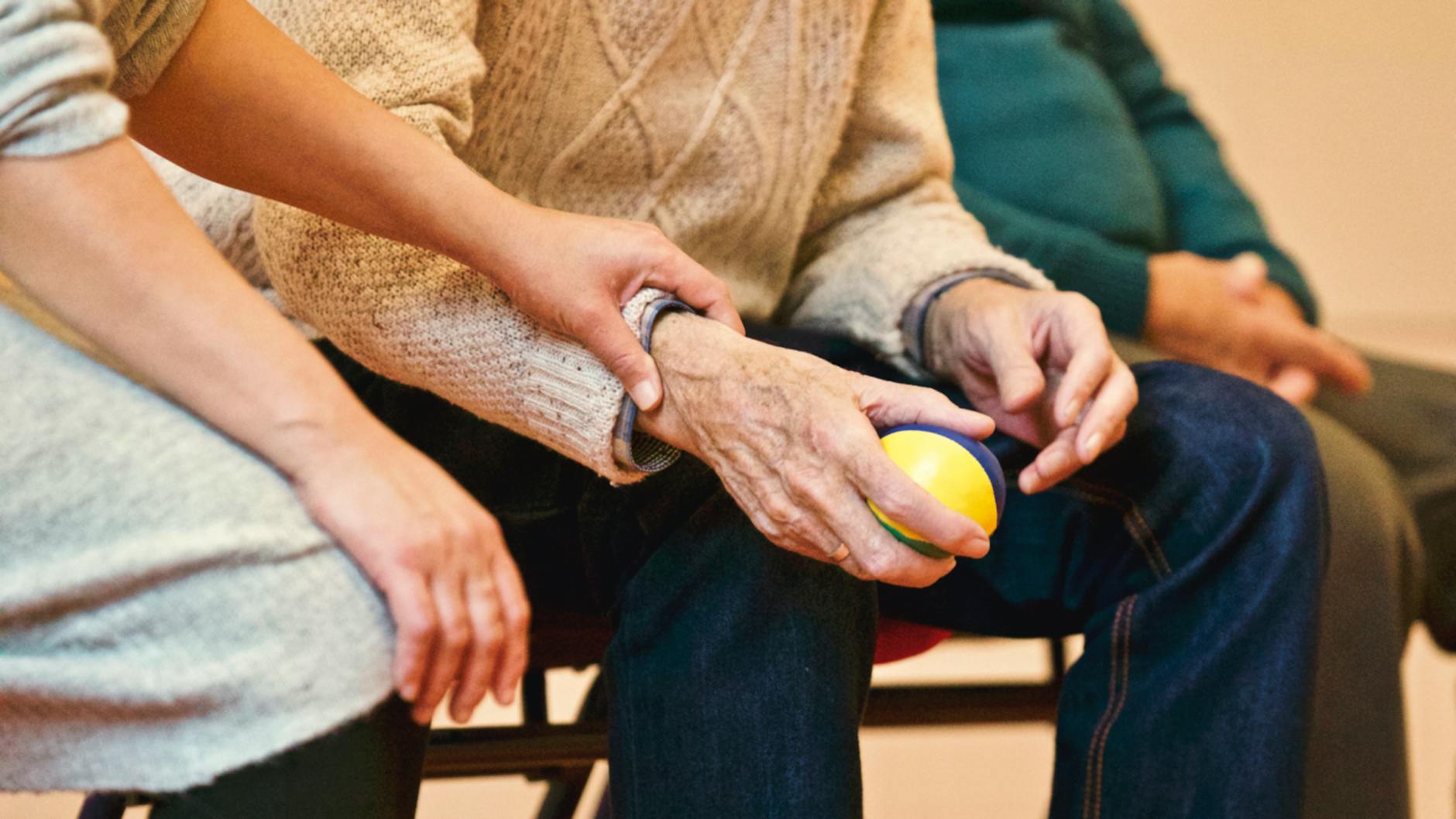 Caregiver holding hands with elderly patient